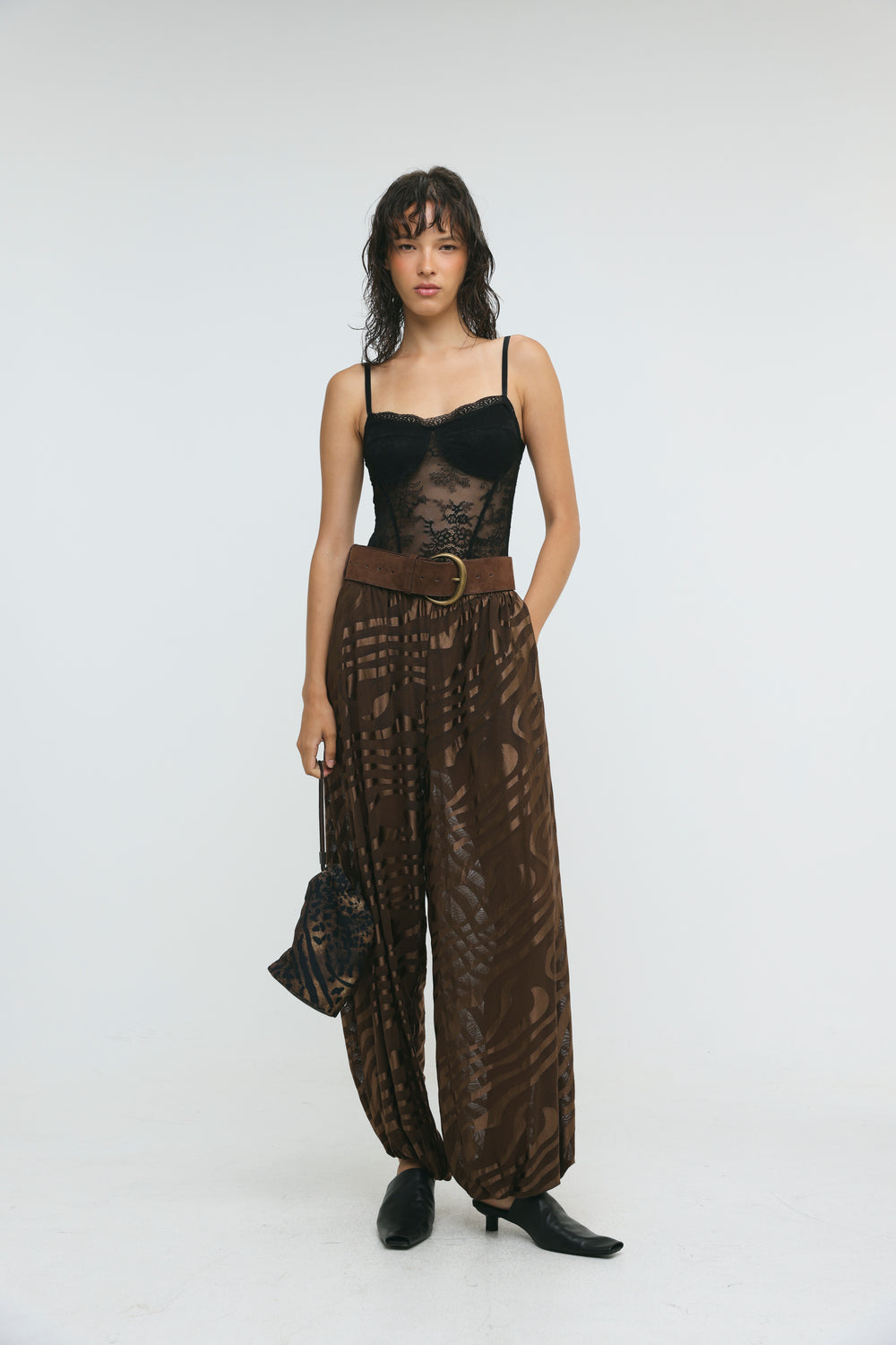 Black lace bodysuit with thin spaghetti straps and sheer patterned overlay shown from the front with slick brown balloon bottoms
