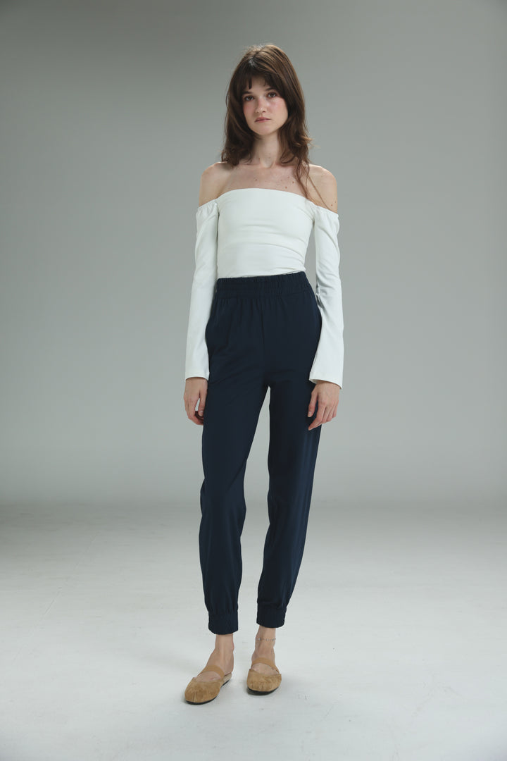 White off-the-shoulder long-sleeve top paired with navy high-waisted bestie navy joggers front view