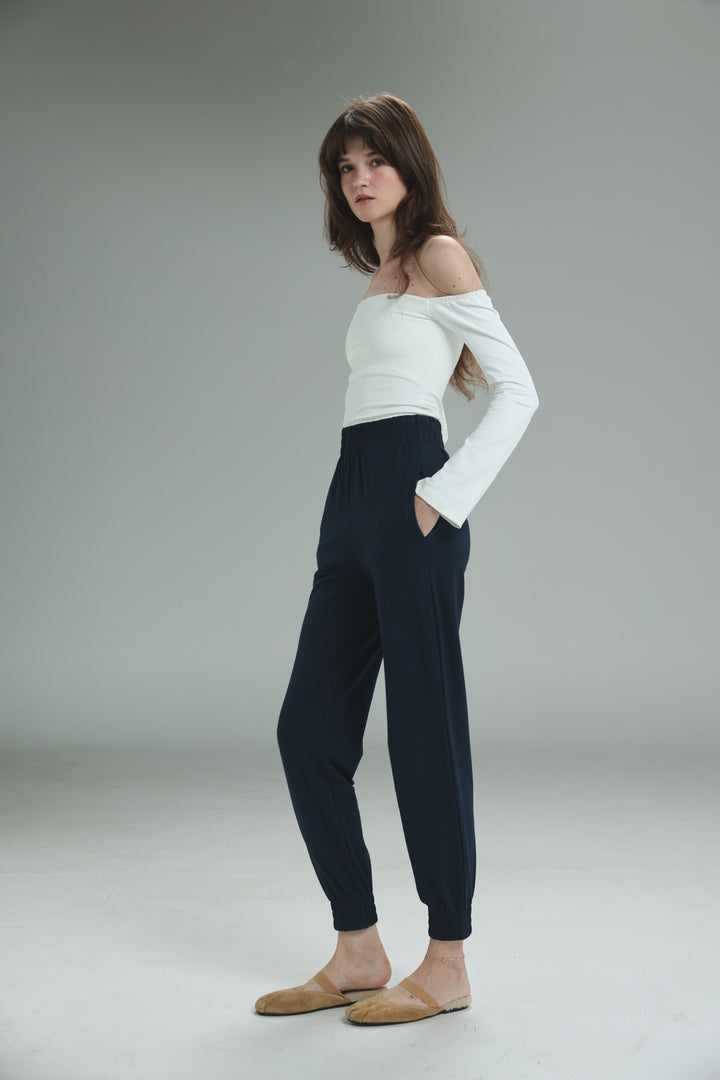 Navy high-waisted jogger pants with elastic cuffs and side pockets shown from the front in bestie navy joggers style