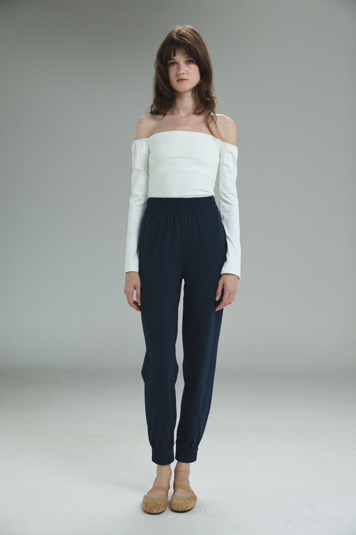 White off-the-shoulder long-sleeve top with structured bodice and subtle vertical seams shown from the front