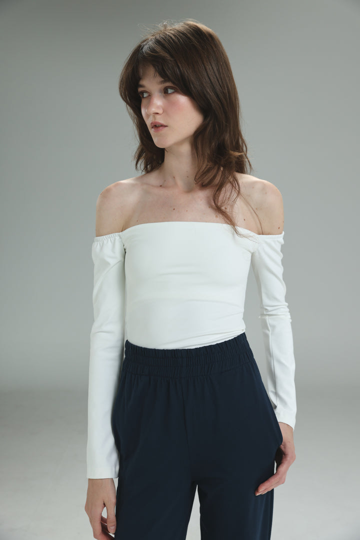 White off shoulder top with long sleeves fitted silhouette and subtle ruching at the shoulders viewed from front