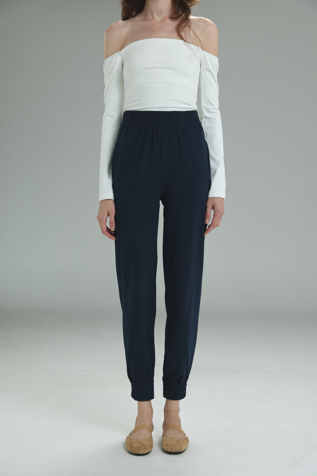 Navy blue high-waisted joggers with a sleek tailored fit and elastic waistband shown from the front