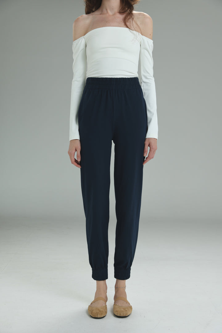 Navy blue high-waisted joggers with a sleek tailored fit and elastic waistband shown from the front