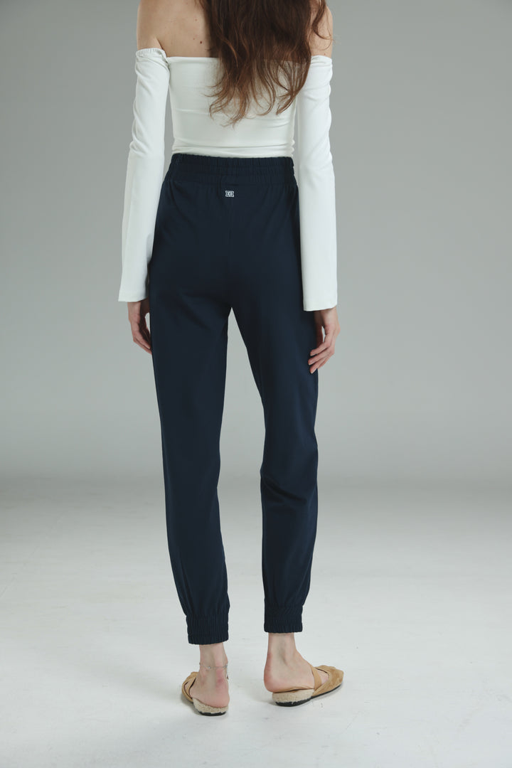 Navy blue tailored joggers with a sleek modern cut and subtle elastic waistband detail shown from the front