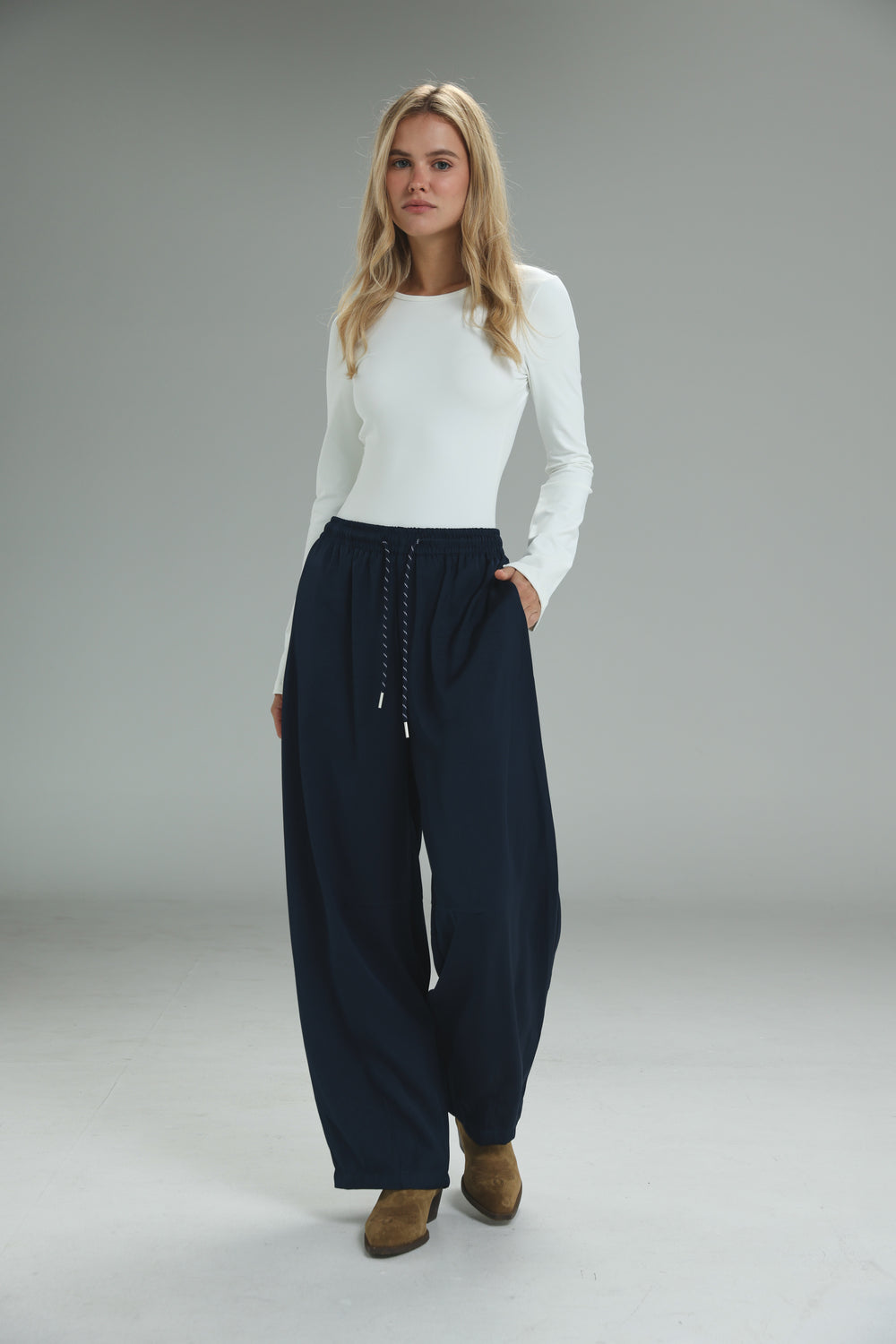 Navy blue wide-leg golden navy bottoms with a drawstring waist and subtle side pockets shown from the front