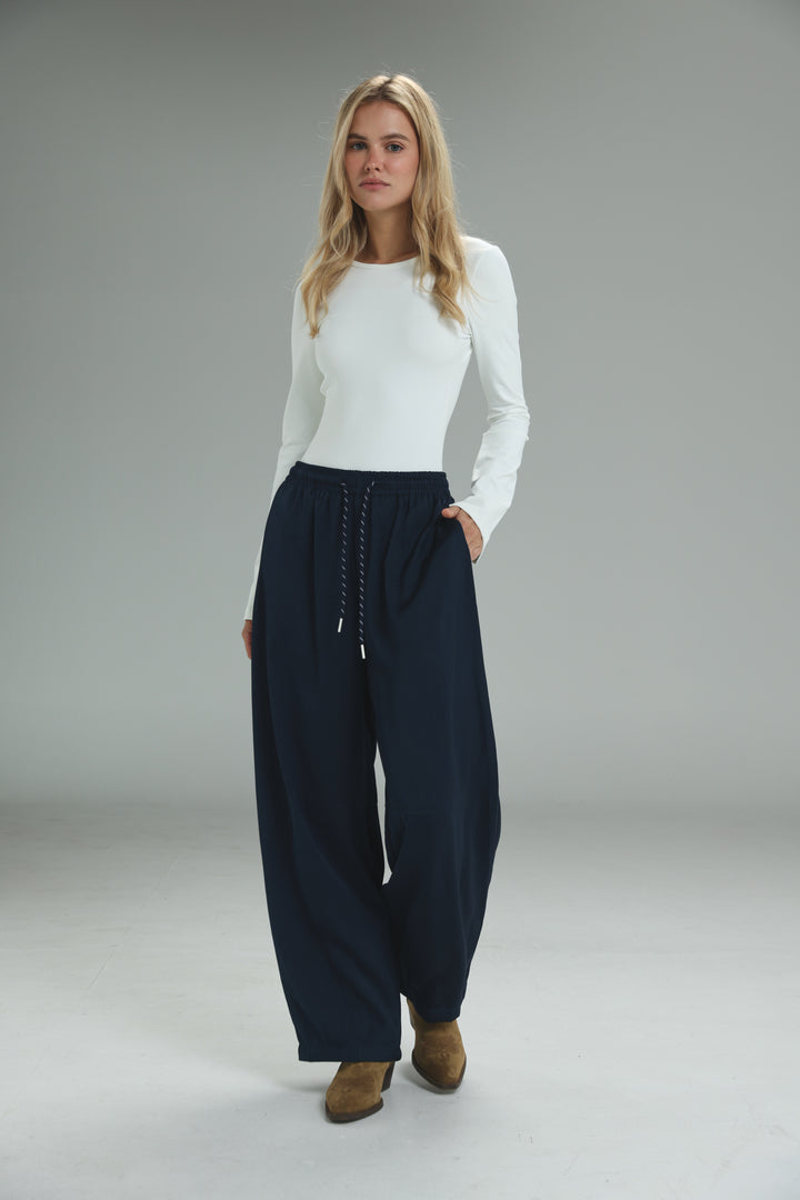 Navy blue wide-leg golden navy bottoms with a drawstring waist and subtle side pockets shown from the front
