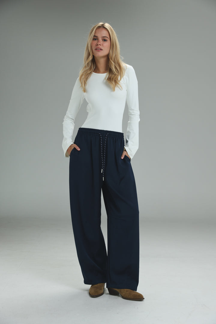 Navy blue wide-leg trousers with drawstring waistband shown from the front in golden navy bottoms product