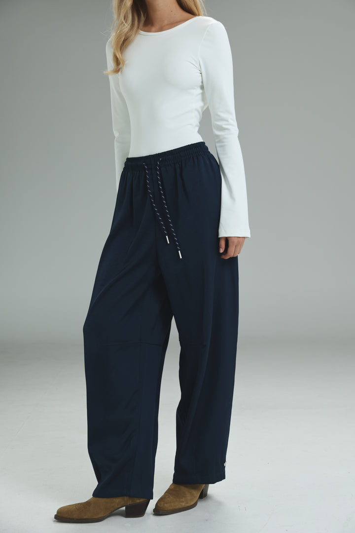 Navy blue wide-leg trousers with a drawstring waist and subtle side pockets shown from the front