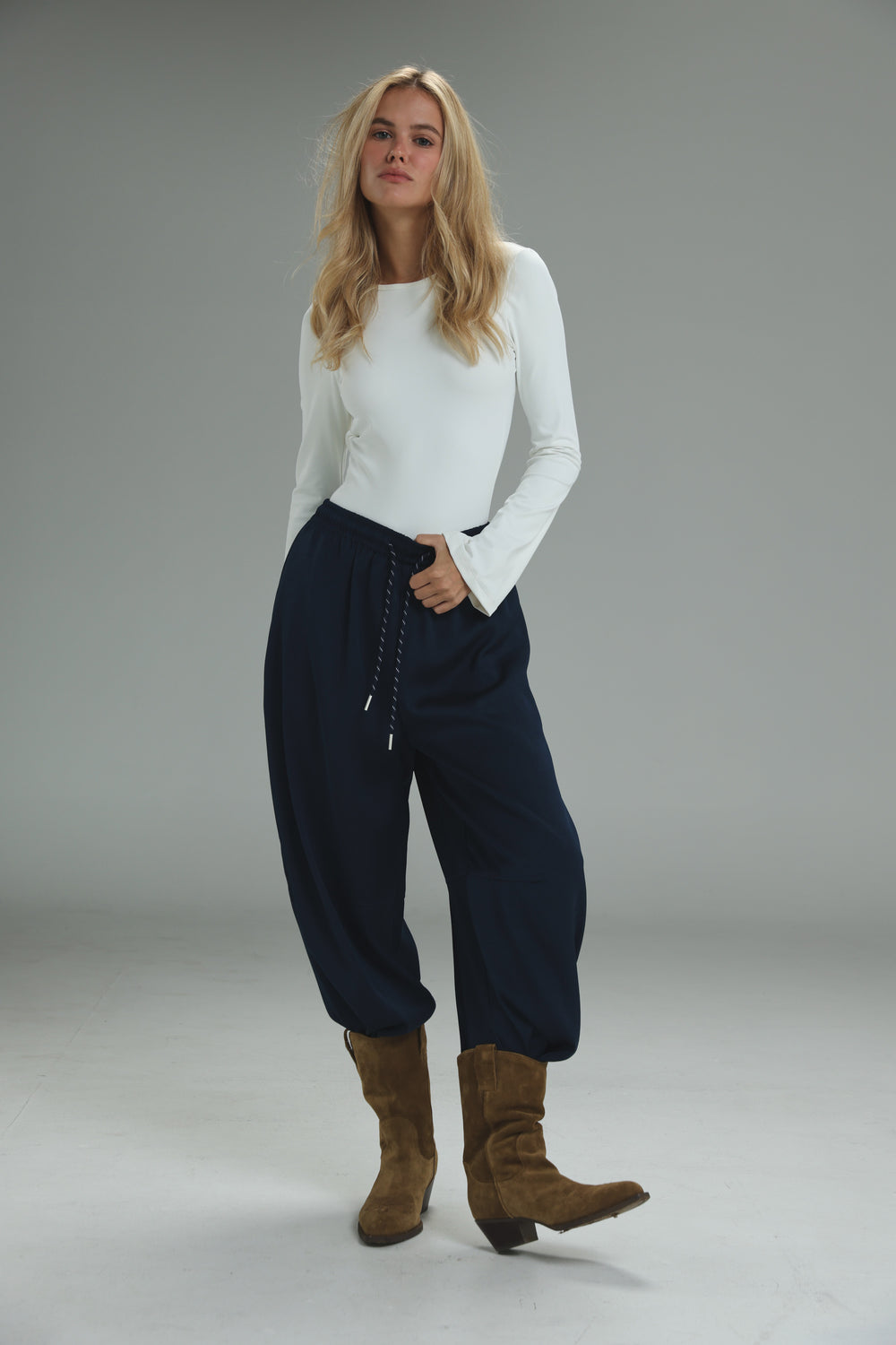 Navy blue drawstring pants with a relaxed tapered fit and soft fabric texture shown from the front