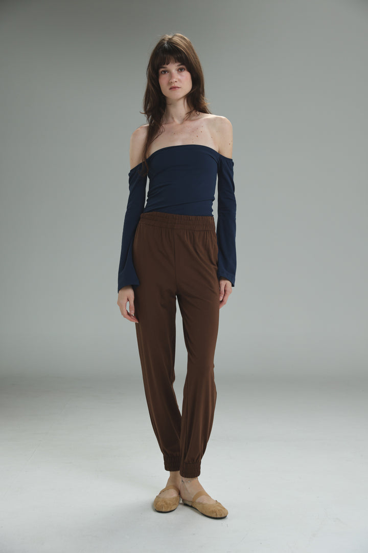 Navy blue off the shoulder long sleeved top with fitted bodice and relaxed flowing fabric front view