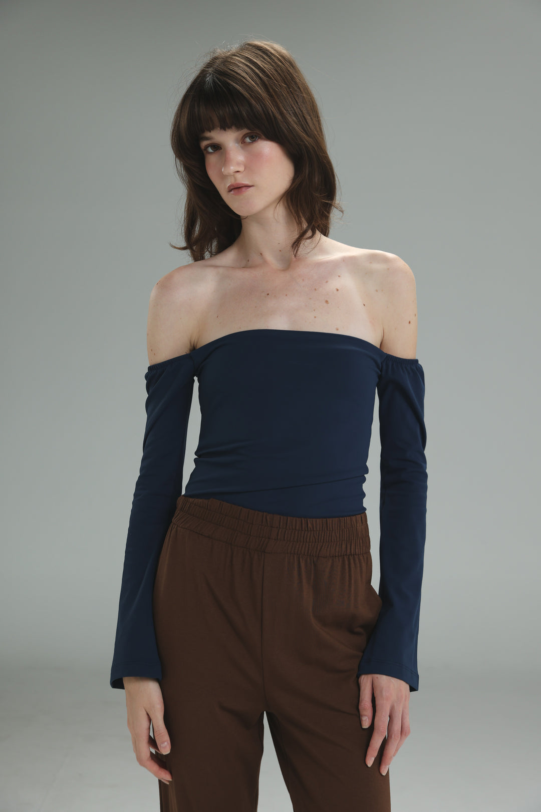 A navy lycra off the shoulder top with long sleeves and a fitted stretchy design shown from the front