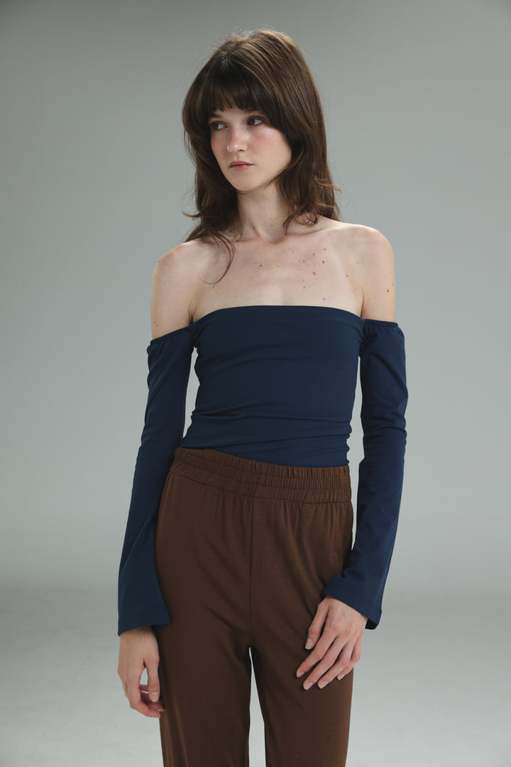 Navy off shoulder top with long sleeves, fitted ribbed bodice, and slightly flared sleeves shown from the front