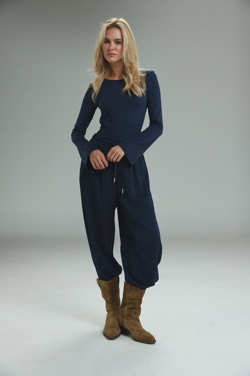 Navy blue long-sleeved jumpsuit with relaxed fit and drawstring waist shown from the front