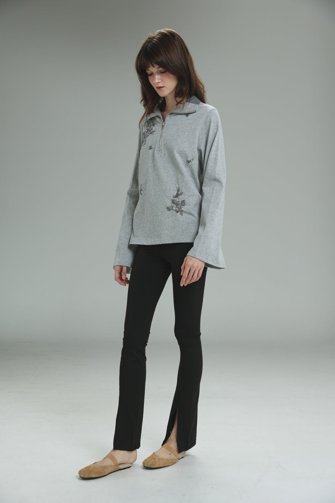 Light gray long-sleeved zip-up polo with delicate floral embroidery on chest and sleeves shown from the front