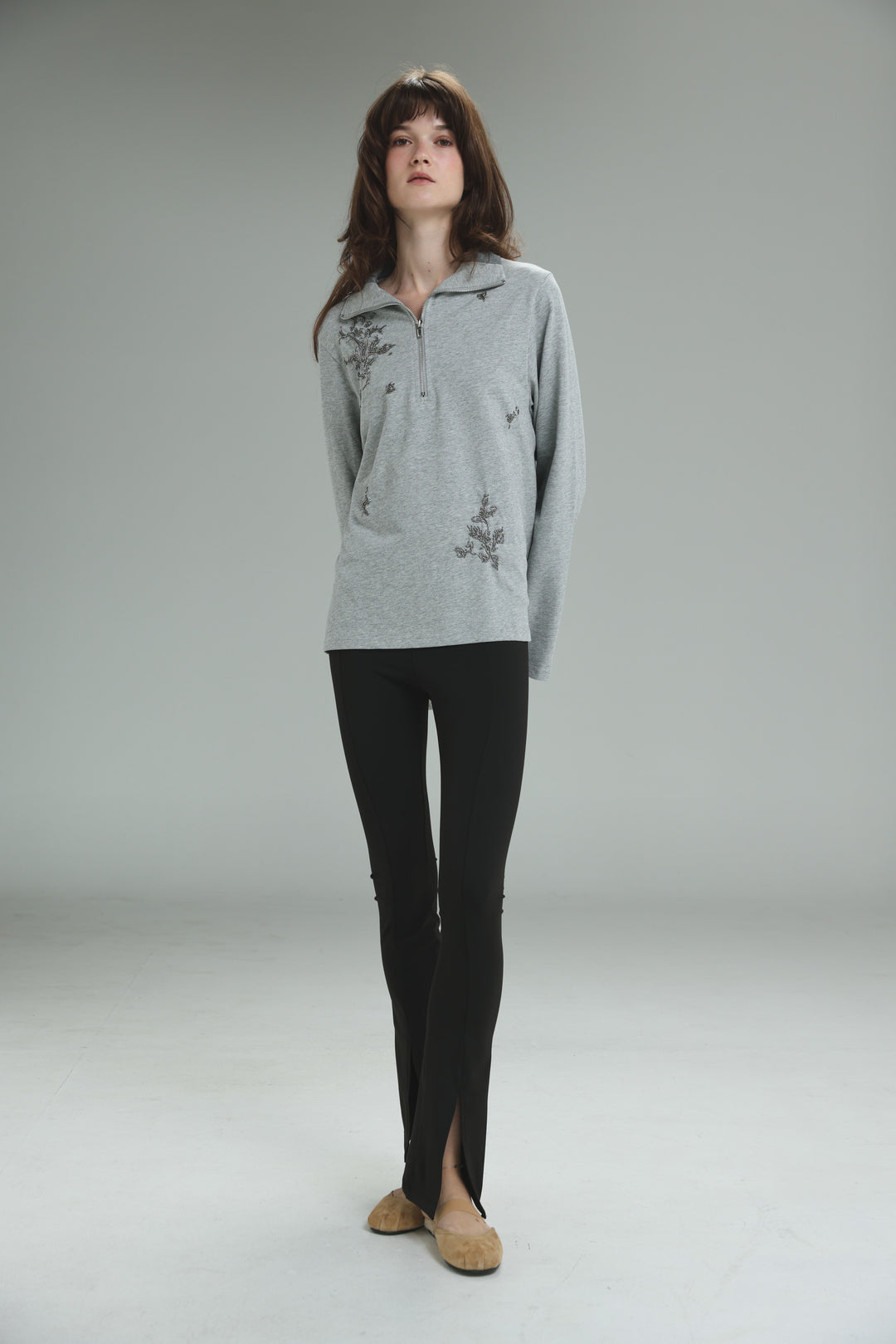 Light gray long-sleeved Joy Grey Polo with delicate floral embroidery and a half-zip neckline shown from the front