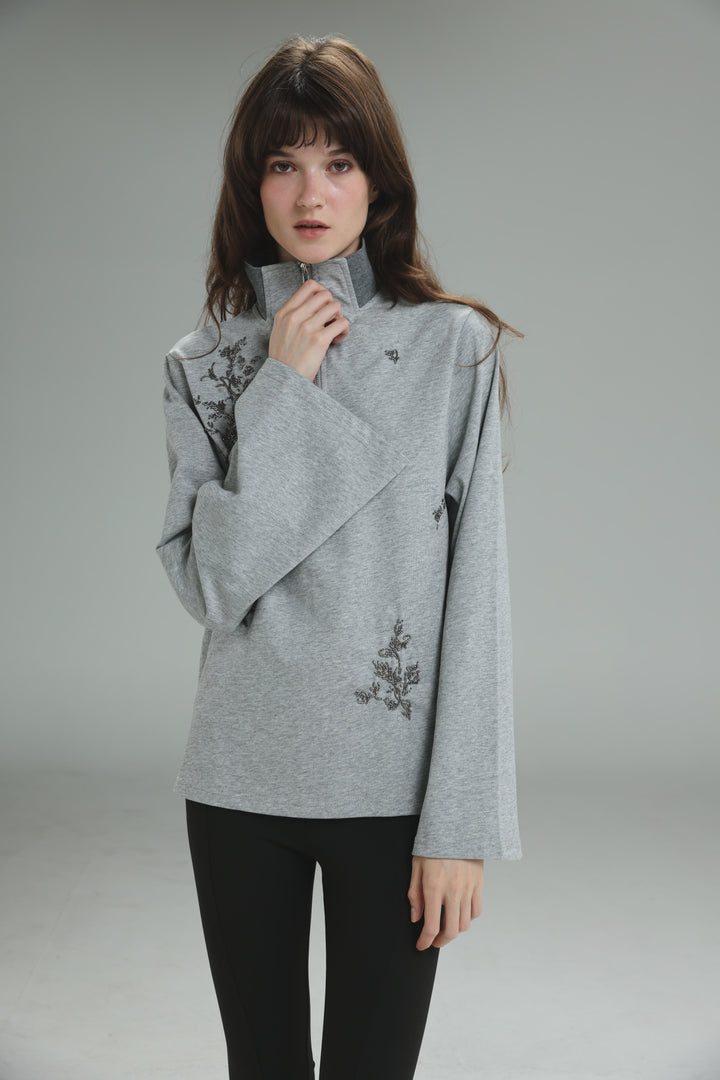 Joy grey polo long-sleeved top with high collar and black floral embroidery shown from the front