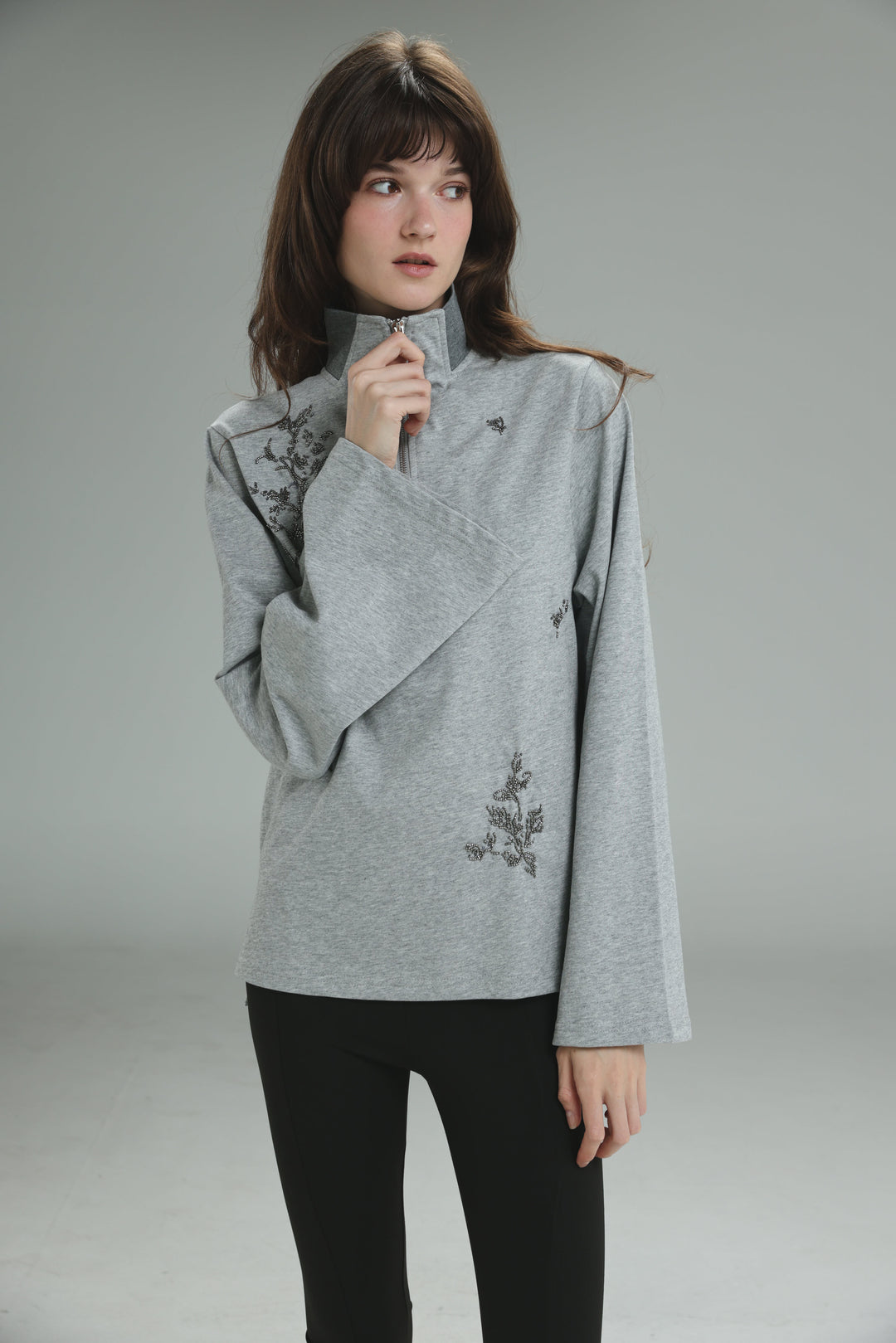 Gray high-neck sweatshirt named Joy Grey Polo with delicate black floral embroidery on sleeves and front shown from front view