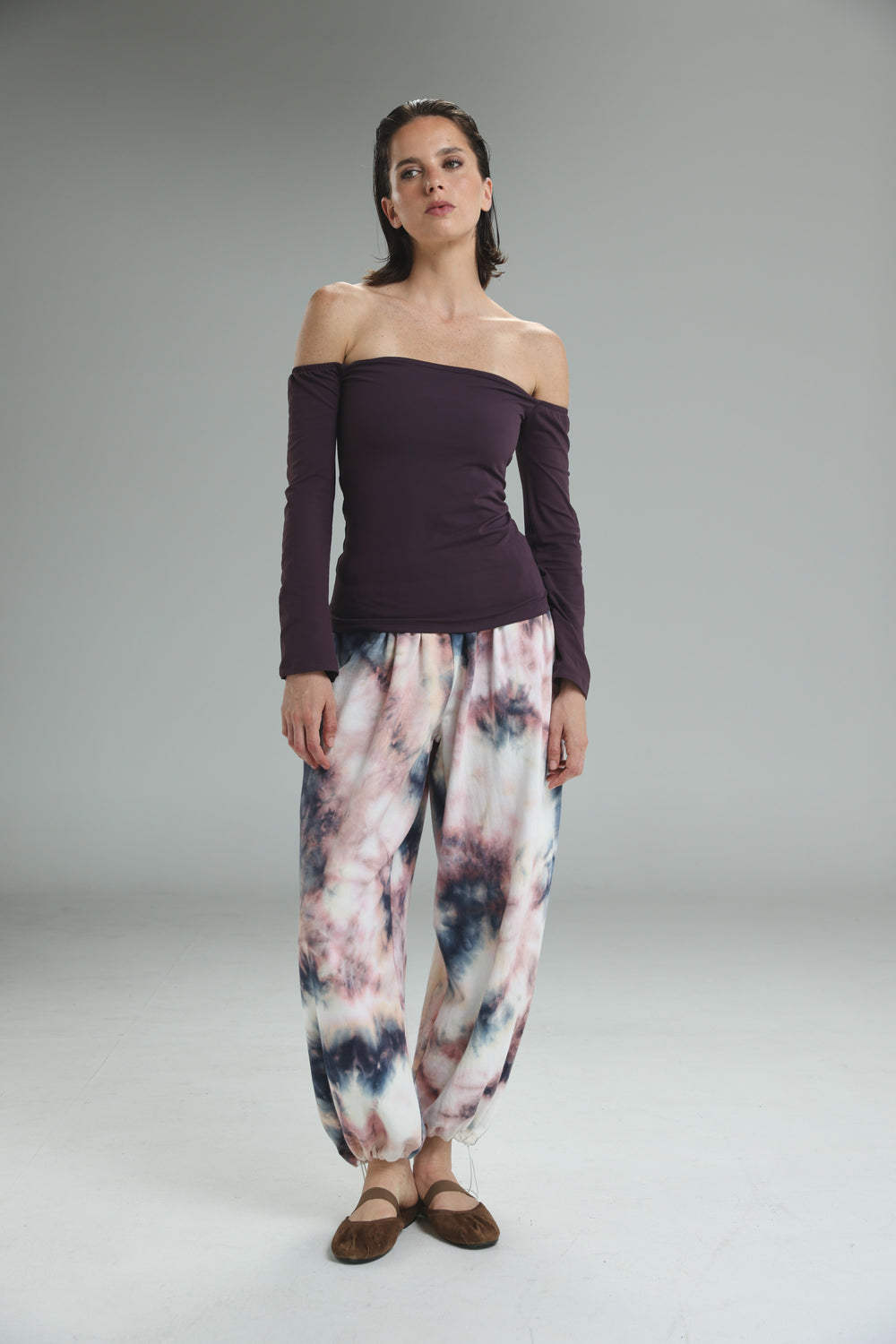 Lycra purple off shoulder top paired with loose-fitting tie-dye harem pants in pastel pinks, purples, and dark blue accents