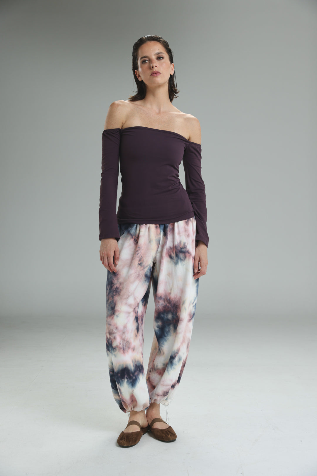 Lycra purple off shoulder top paired with loose-fitting tie-dye harem pants in pastel pinks, purples, and dark blue accents