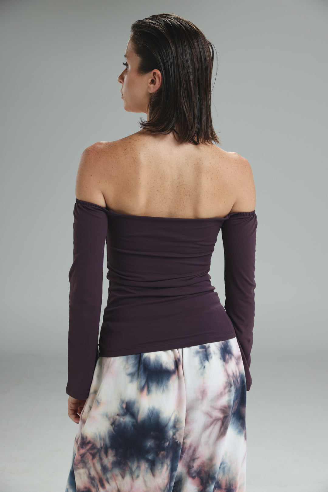 Lycra purple off shoulder top with long sleeves and fitted ribbed waistband shown from the front