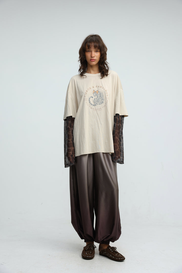 Cream-colored oversized t-shirt with circular tiger graphic layered over sheer leopard-print long sleeves front view