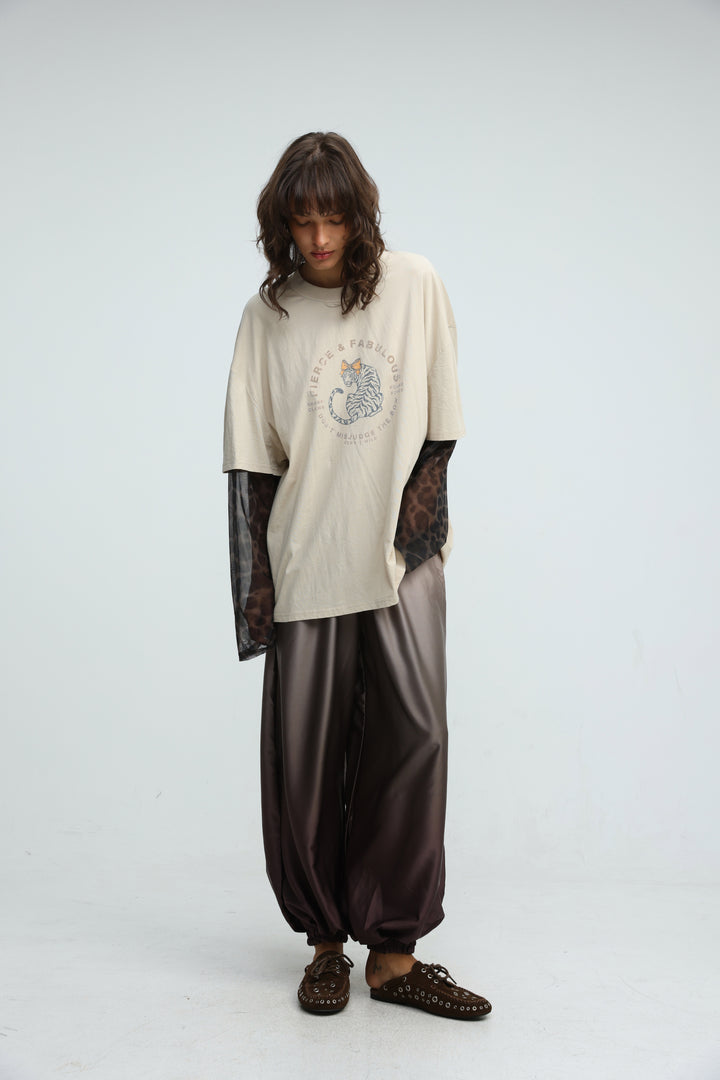 Beige oversized t-shirt with circular graphic print and sheer leopard print sleeves shown from the front