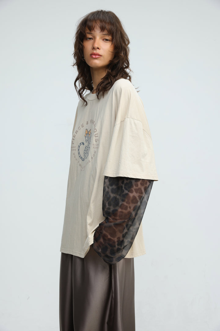 Cream-colored oversized t-shirt with circular graphic print and sheer leopard-print mesh sleeves front view