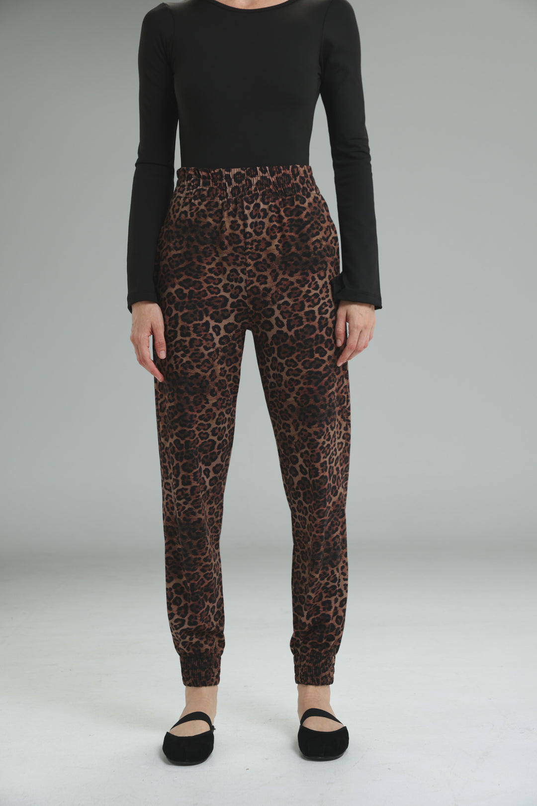Brown leopard-print jogger pants with elastic waistband and ribbed cuffs shown from the front view