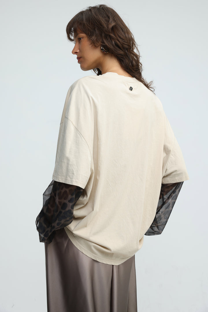 Cream beige oversized top with sheer leopard print sleeves shown from the front