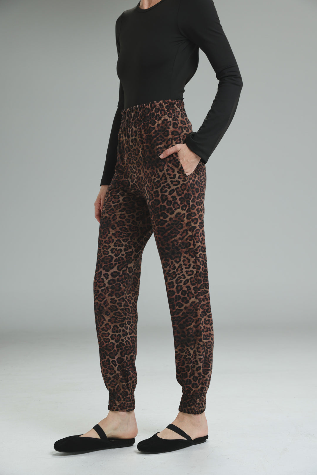 Brown leopard-print jogger pants with elastic waistband and ribbed cuffs shown from the front