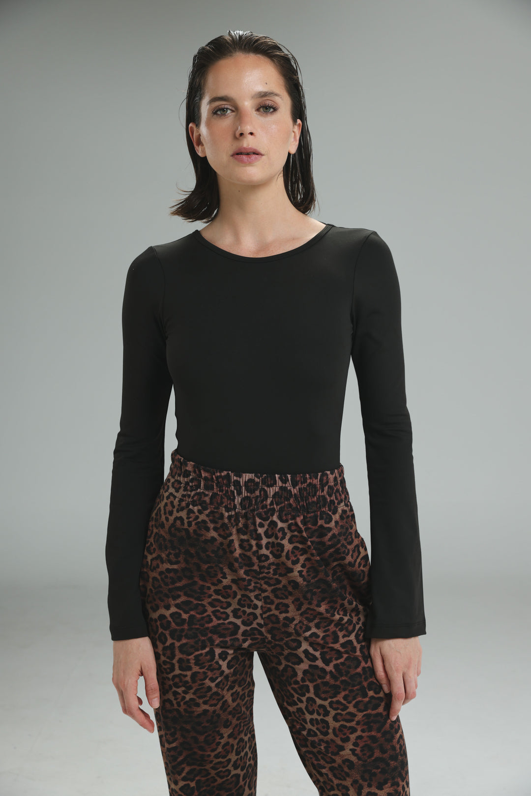 Black long-sleeved lycra bodysuit with round neckline and fitted silhouette shown from the front