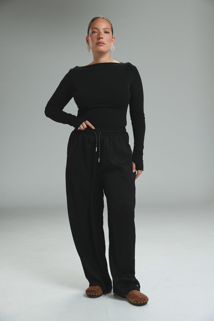 Black long-sleeved top with boat neckline and matching drawstring pants with golden black bottoms color