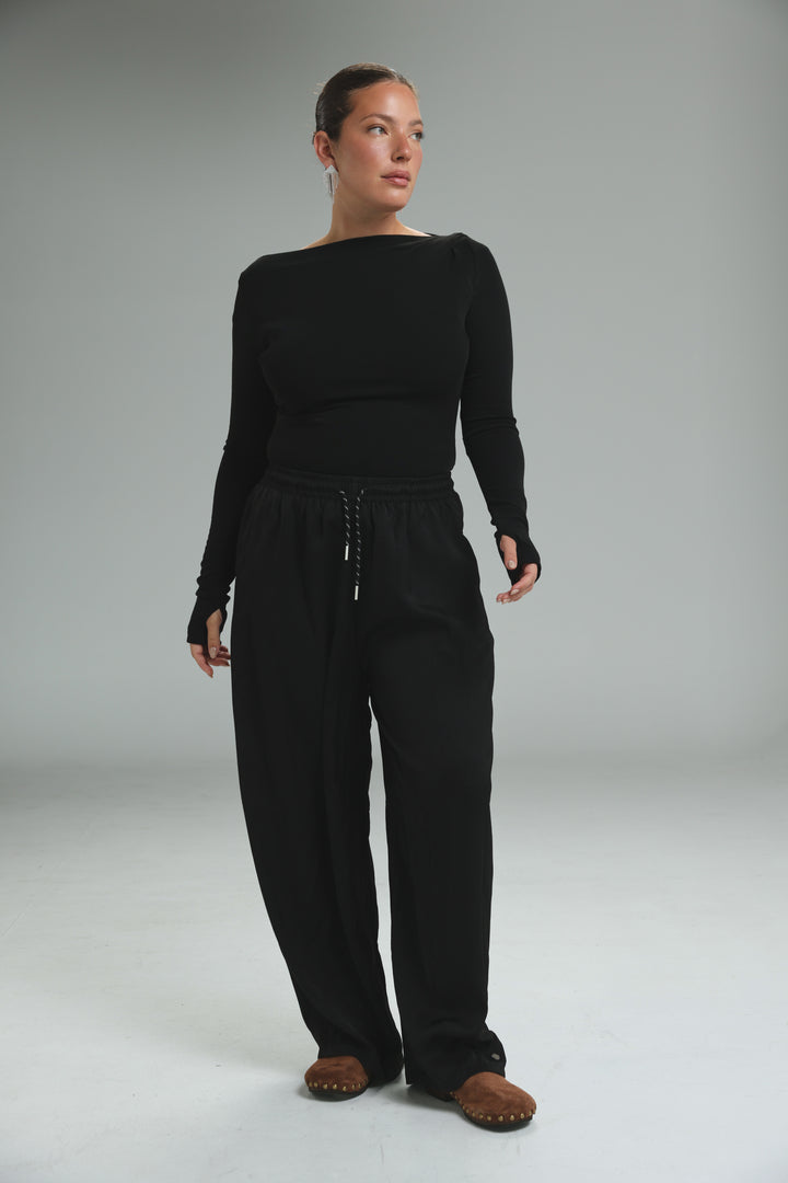 Black long-sleeved off-the-shoulder top with matching wide-leg pants and drawstring waist shown from the front