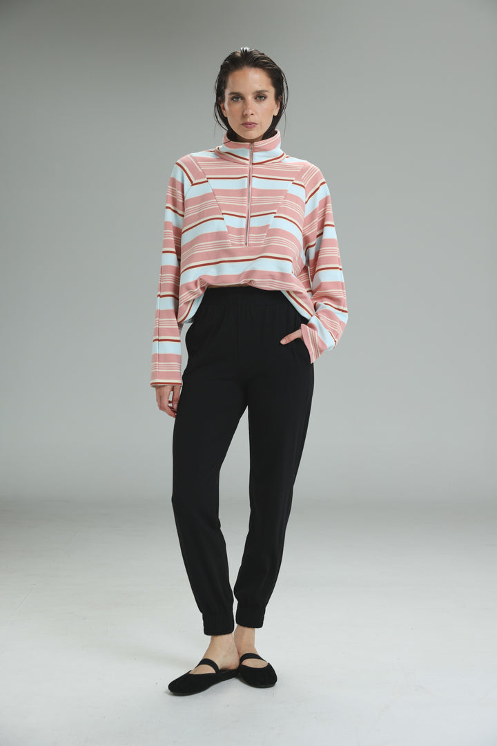 Bestie black joggers paired with a pink and light blue striped half zip sweater with ribbed collar shown from the front