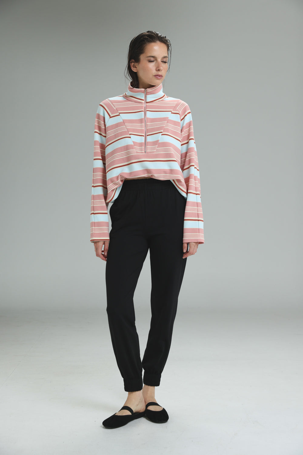 Bestie black joggers paired with a long-sleeved cropped sweater with pink and light blue horizontal stripes front view