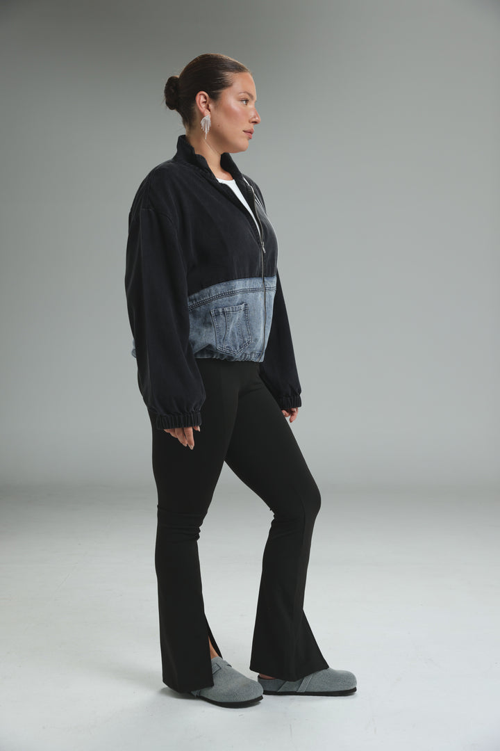 Soft denim panel jacket front view with black jacket and contrasting light blue denim panel across the lower torso