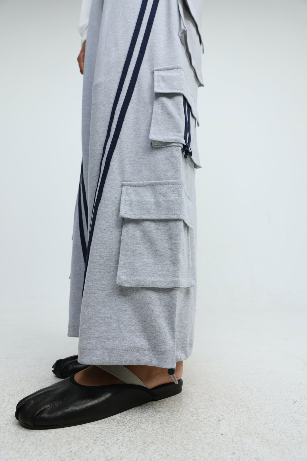 Port Grey joggers in light gray with navy blue vertical stripes and multiple front flap pockets visible from the side