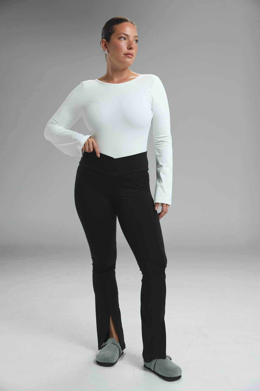 Black high-waisted front slit leggings with flare design shown from the side