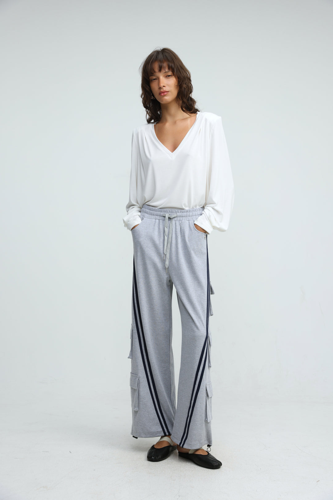 Light gray wide-leg Port Grey joggers with navy blue side stripes and flap pockets shown from the front