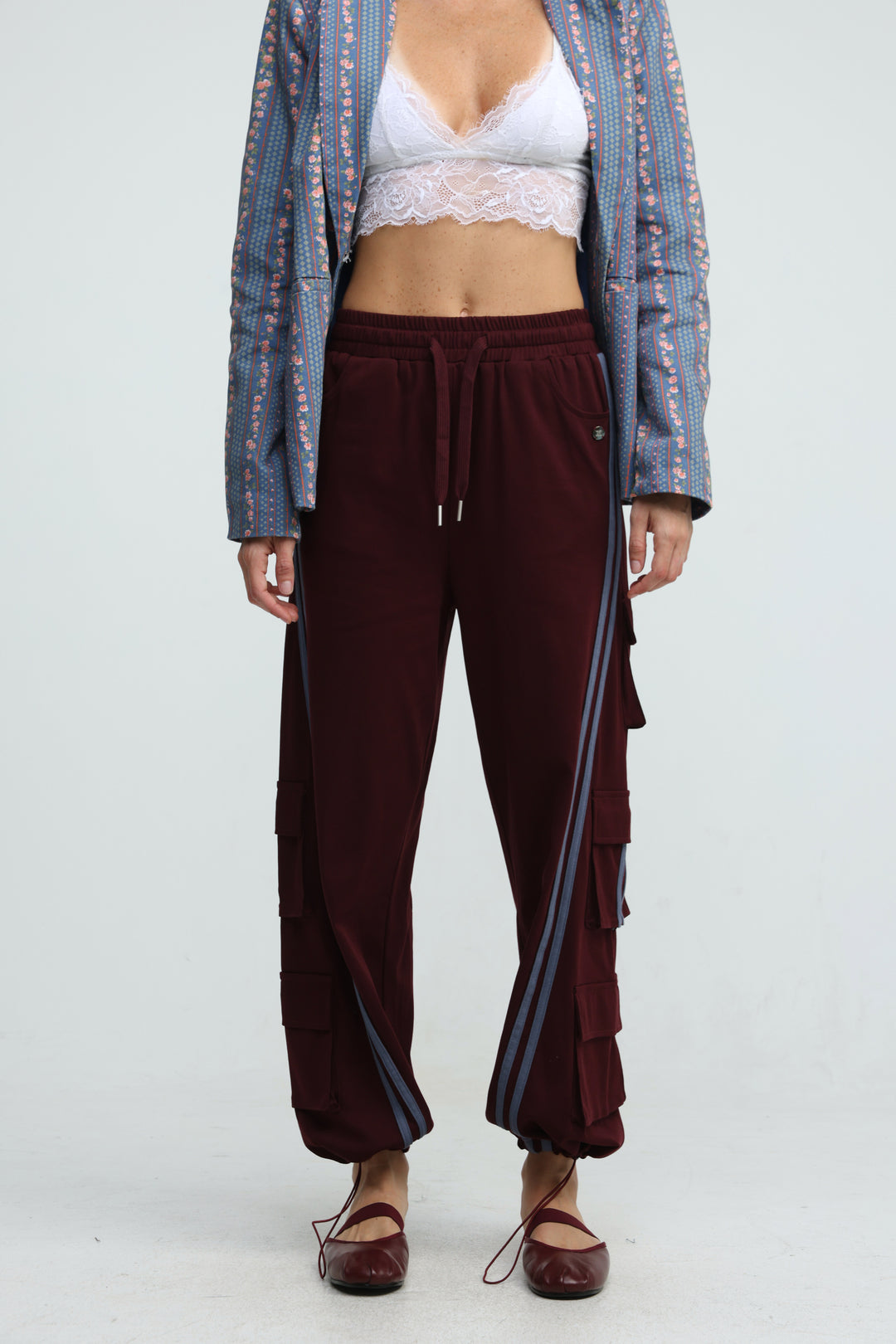 Maroon velour joggers with striped side panels and tiered cargo pockets shown from the front