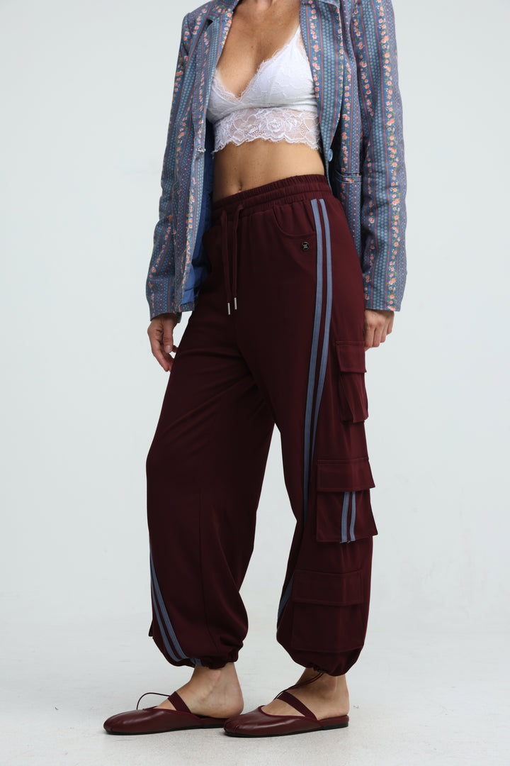 Port wine joggers in maroon with vertical striped side panels and tiered pocket detailing shown from the front