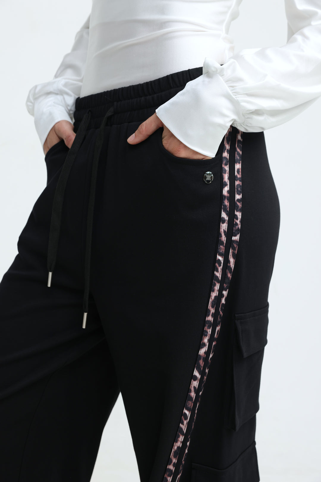 Port black joggers with black cargo pants featuring a leopard-print side stripe and elastic waistband visible from front view