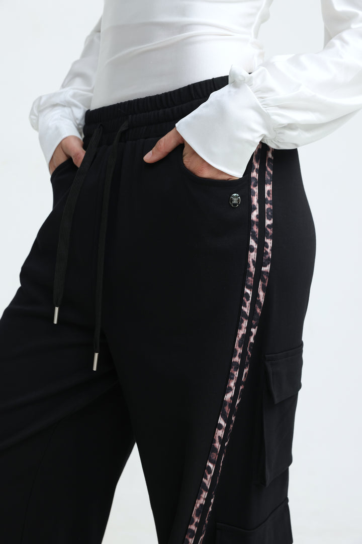Port black joggers with black cargo pants featuring a leopard-print side stripe and elastic waistband visible from front view