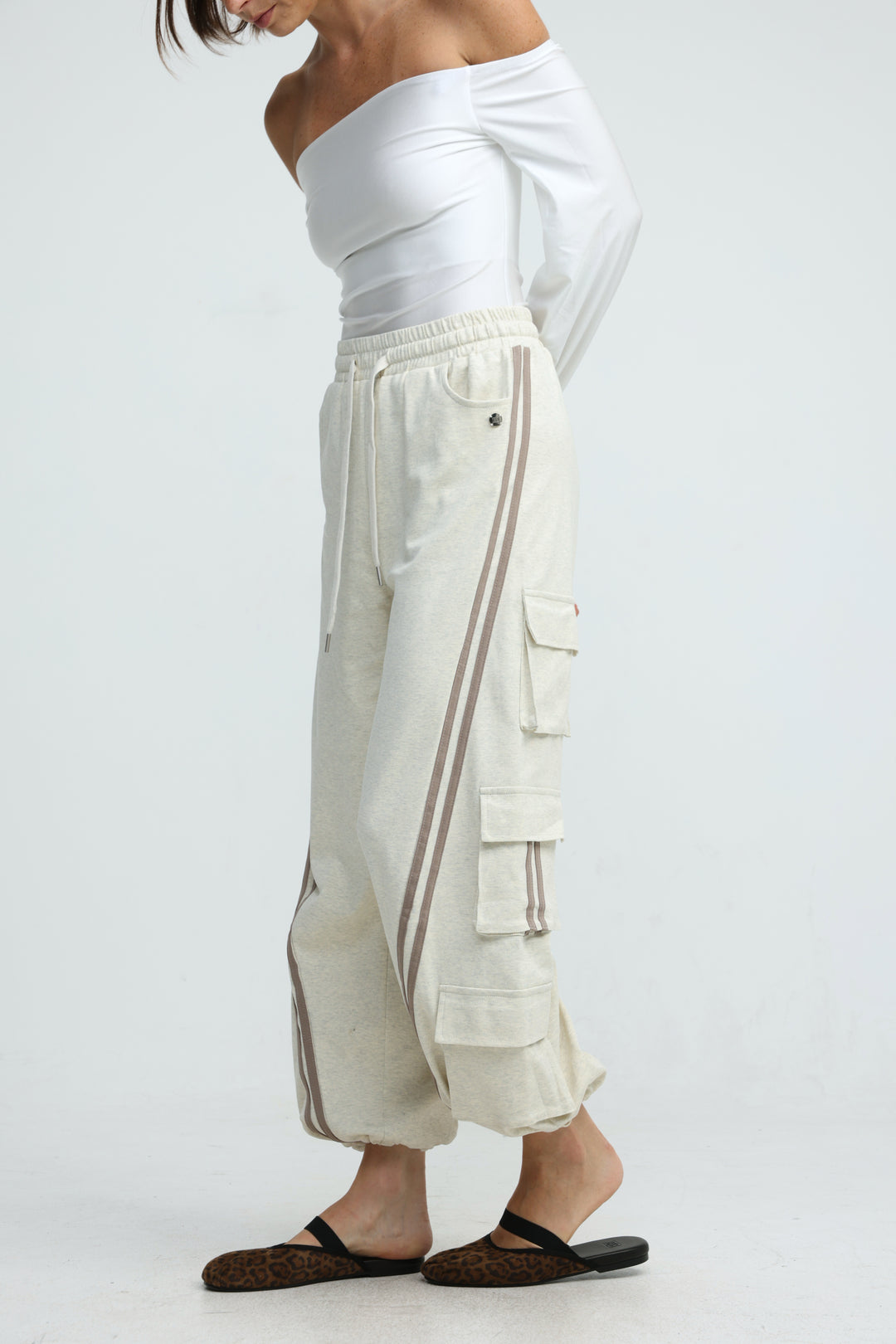Cream-colored Port cream joggers with two vertical gray stripes and multiple flap pockets shown from the front