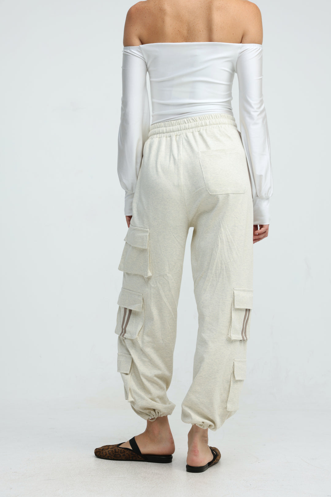 Off-white cargo pants with multiple pockets and elastic cuffs shown front view labeled port cream joggers