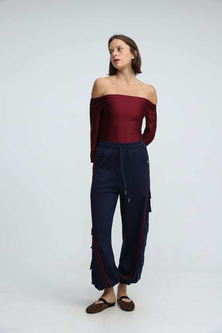 Port navy joggers are navy blue cargo pants with red side panels and frayed hems shown from the front view