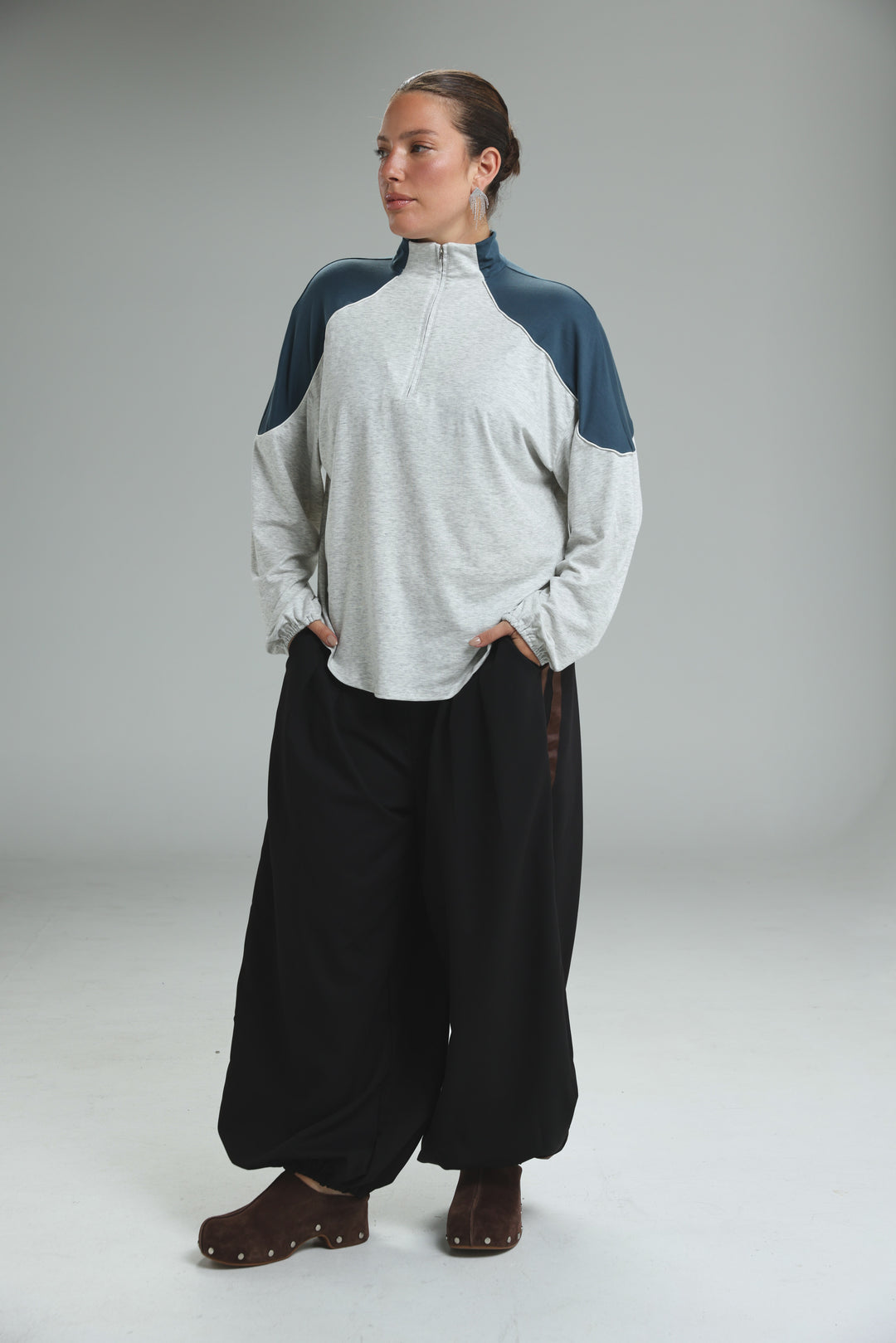 A woman wearing an allure cream sweatshirt with navy blue shoulder panels and light gray body fabric front view