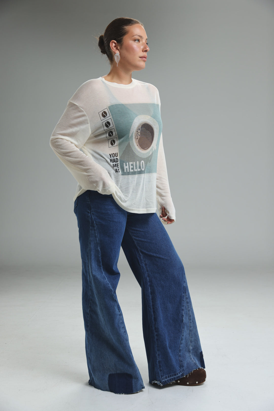 White long-sleeved hello coffee cream shirt with teal circular design and hello text on the front