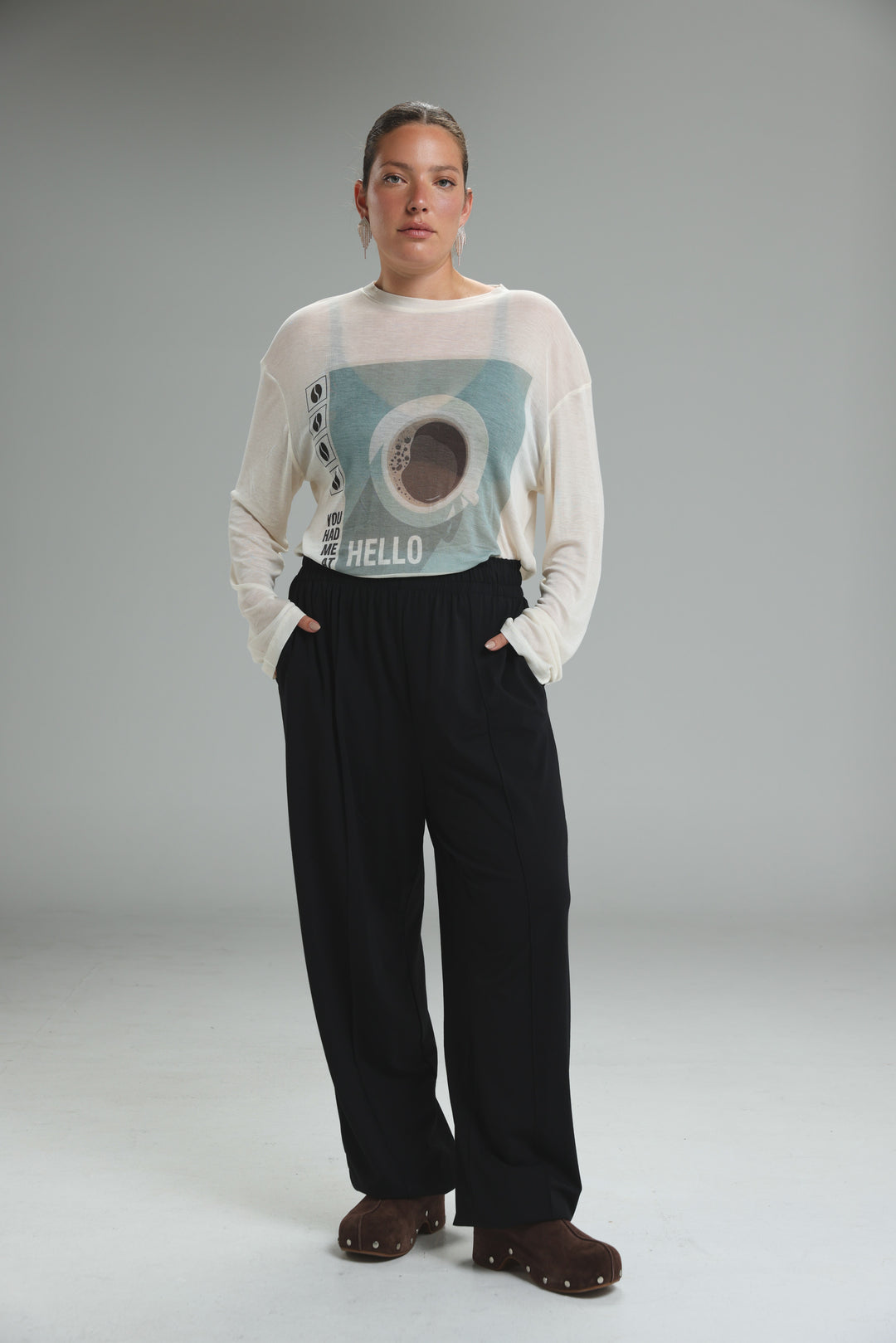 White long-sleeved top with light blue and brown hello graphic paired with best black joggers front view