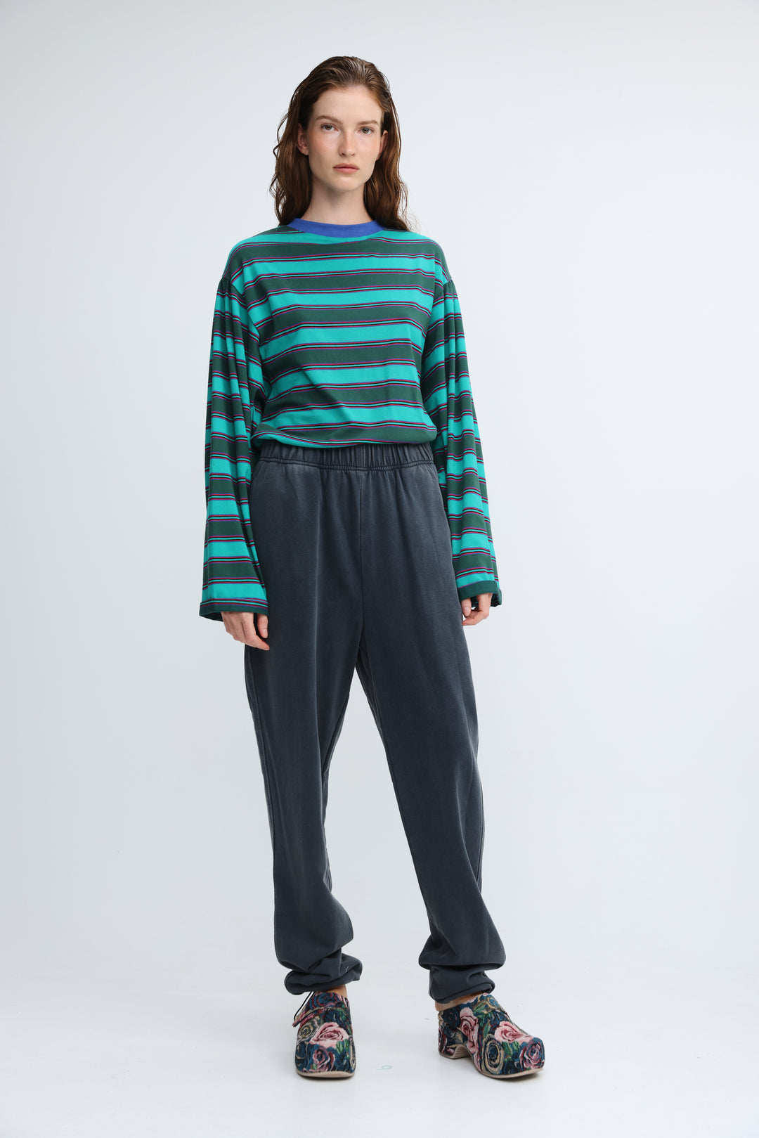 Zone dark blue joggers shown front view with loose fit and paired with long-sleeved teal and dark green striped top